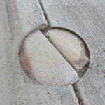 Patched Holes in Garage Floor:  Structural Issues Or For Pest Control Treatment?