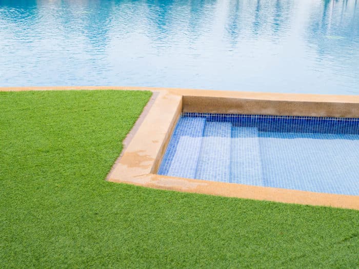Artificial grass leading up to a pool and jaccuzi