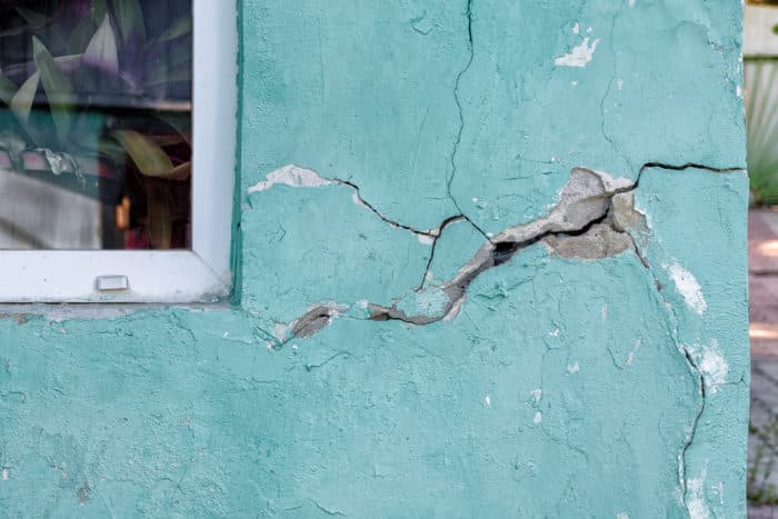 Serious Stucco crack at window, blue house