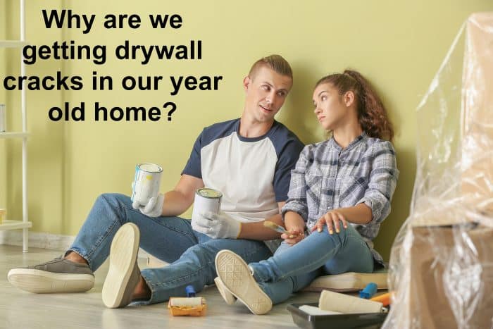 Couple looking at drywall cracks in new house