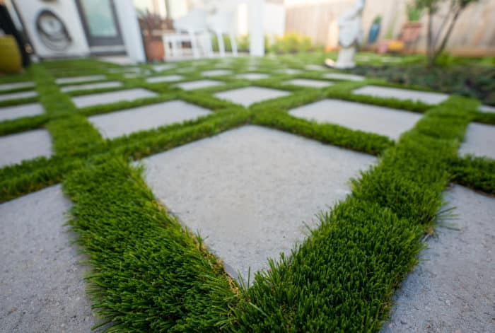 Fake grass between concrete paver stones