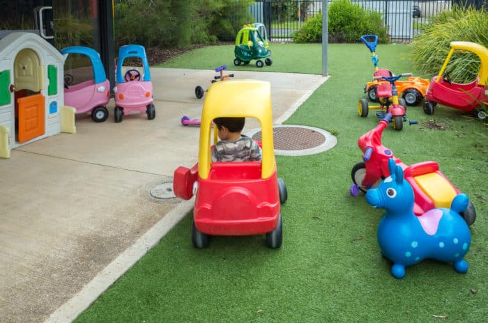 kids and toys in a backyard with fake turf
