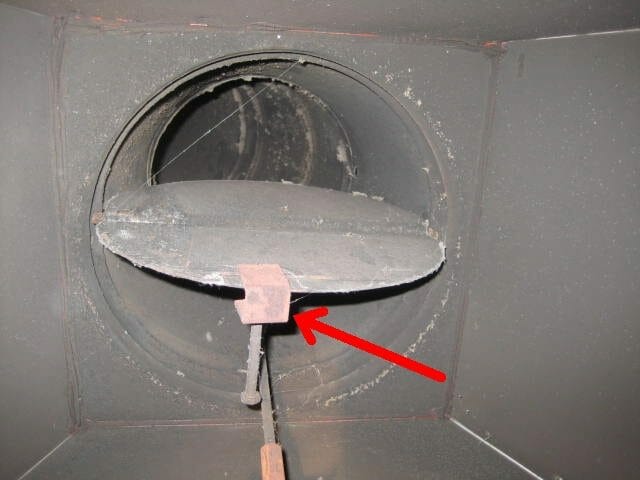 Fireplace damper clamp seen on a flue