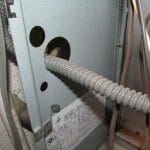 Flexible gas line against sharp metal edge of furnace