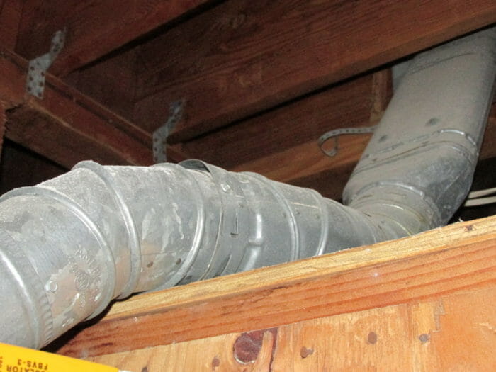 Water heater vent against wood